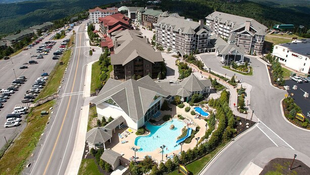 A resort with multiple buildings, a swimming pool, and a parking lot.