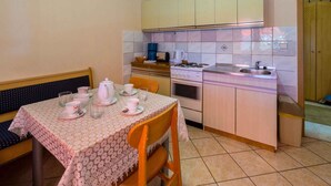 A compact kitchen with a dining table set for four, a stove, and a sink. - Holiday apartment mit Terrasse und Klimaanlage (Dramalj)