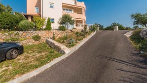 A two-story building with a stone retaining wall and a paved driveway.
