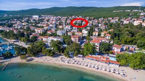 Oversigtsbillede af en kystby med strand, huse og en lysthavn.