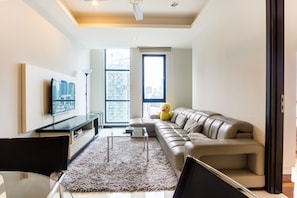 Relax in this stylish living room with a comfortable sofa, flat-screen TV, and city view.