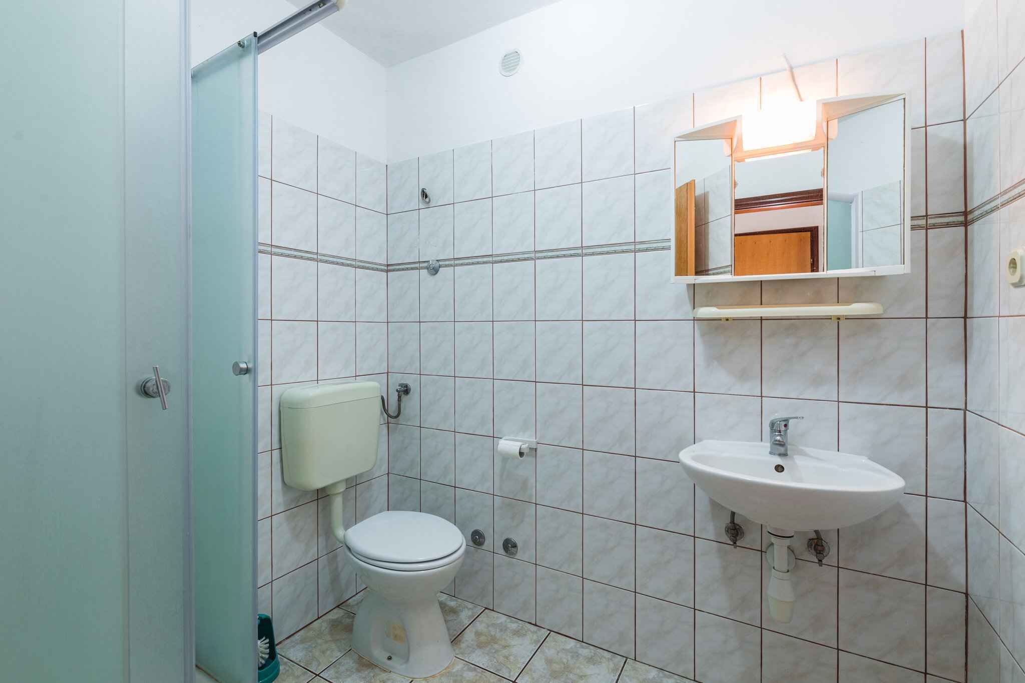 Une salle de bain avec des toilettes, un lavabo et un miroir.