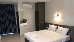 A modern hotel room with a large bed, a mirror, an air conditioning unit, and a wall-mounted light fixture. - The Hub Suratthani Hotel (Surat Thani)