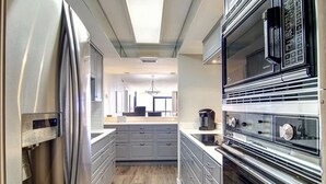 A modern kitchen with stainless steel appliances, grey cabinetry, and a central island.