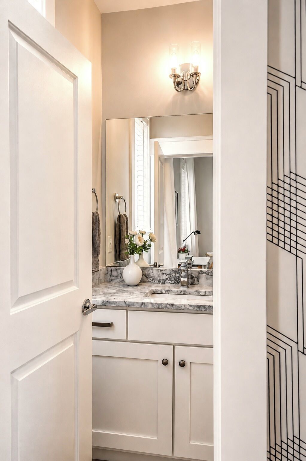 Un baño con encimera de mármol, un lavabo blanco y un espejo encima.
