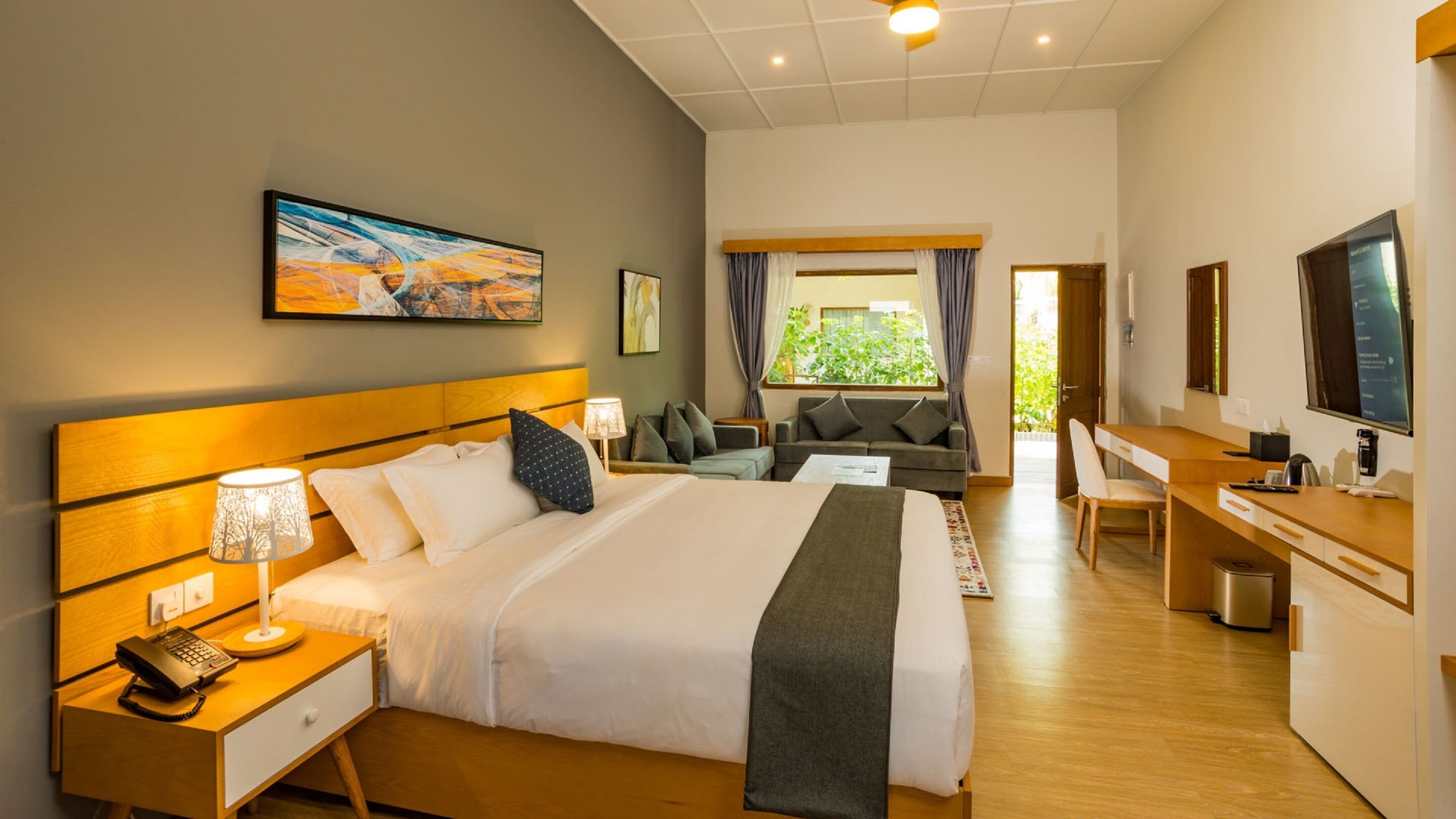 Una habitación de hotel con una cama grande, un escritorio, un sofá y un televisor.