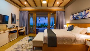 A hotel room with a bed, desk, chair, and a TV. - Fiyavalhu Resort Maldives (Mandhoo)