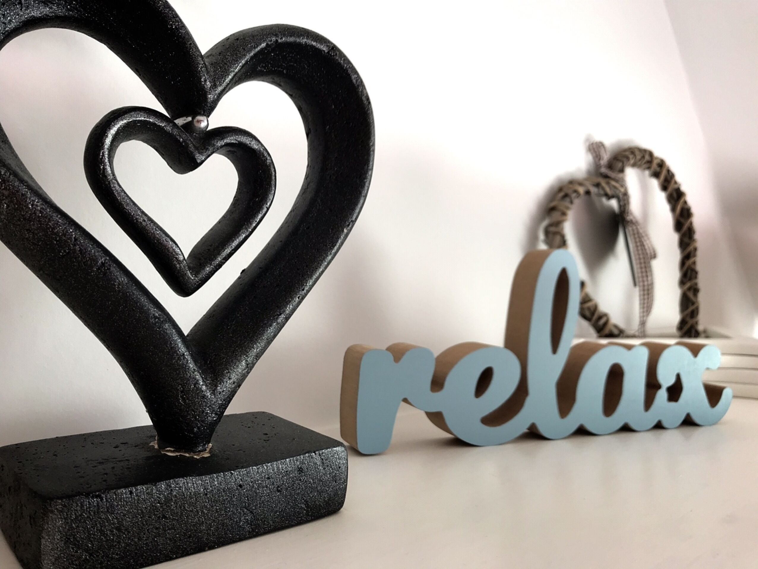 Una escultura decorativa con forma de corazón y un letrero que dice 'relax'.