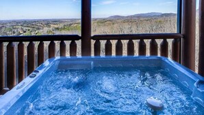 Un jacuzzi con vistas al paisaje a través de una barandilla de madera.