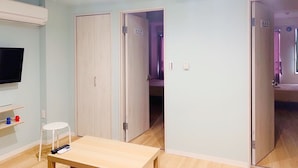 Une pièce avec une télévision, une petite table et une porte donnant sur une autre pièce.