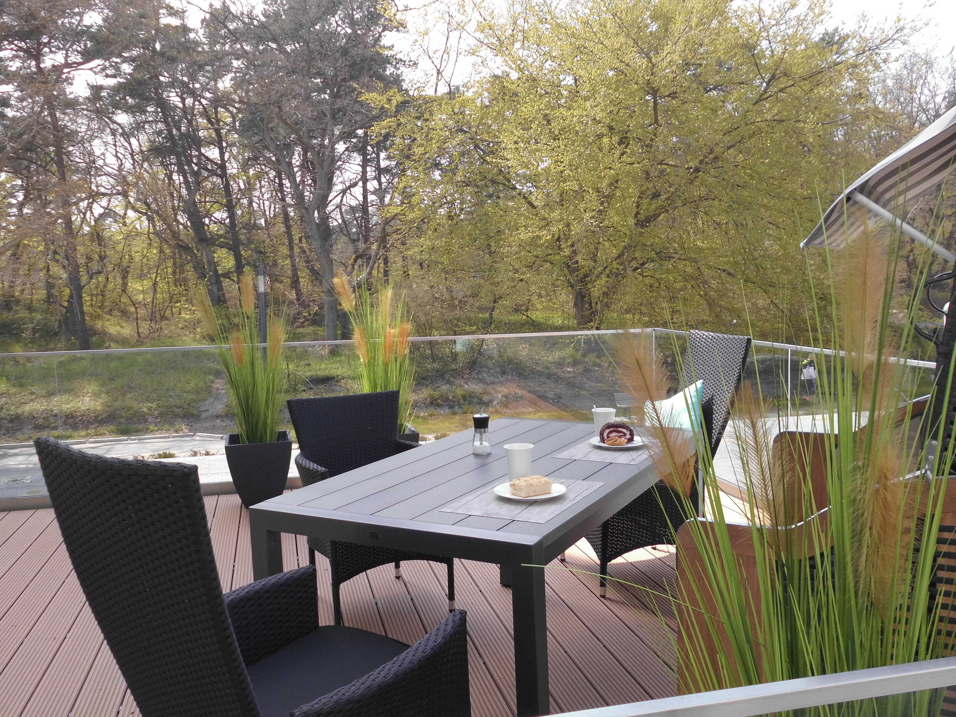 Una terraza con mesa y sillas, con vistas al agua y a los árboles.