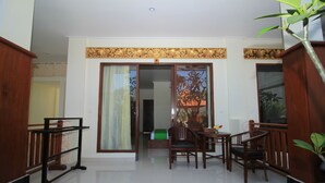 A room with a wooden table and chairs, a bench, and a potted plant. - Brata Cottage Bisma Ubud by Summer Stay (Ubud)