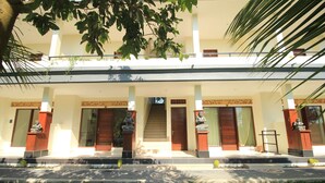 A two-story building with a central staircase, a covered entrance, and statues on either side. - Brata Cottage Bisma Ubud by Summer Stay (Ubud)