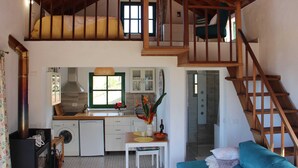 A compact, two-story home with a loft bedroom, a kitchen with modern appliances, and a staircase connecting the floors.