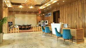 A modern interior with wooden paneling, a reception desk, and blue chairs.