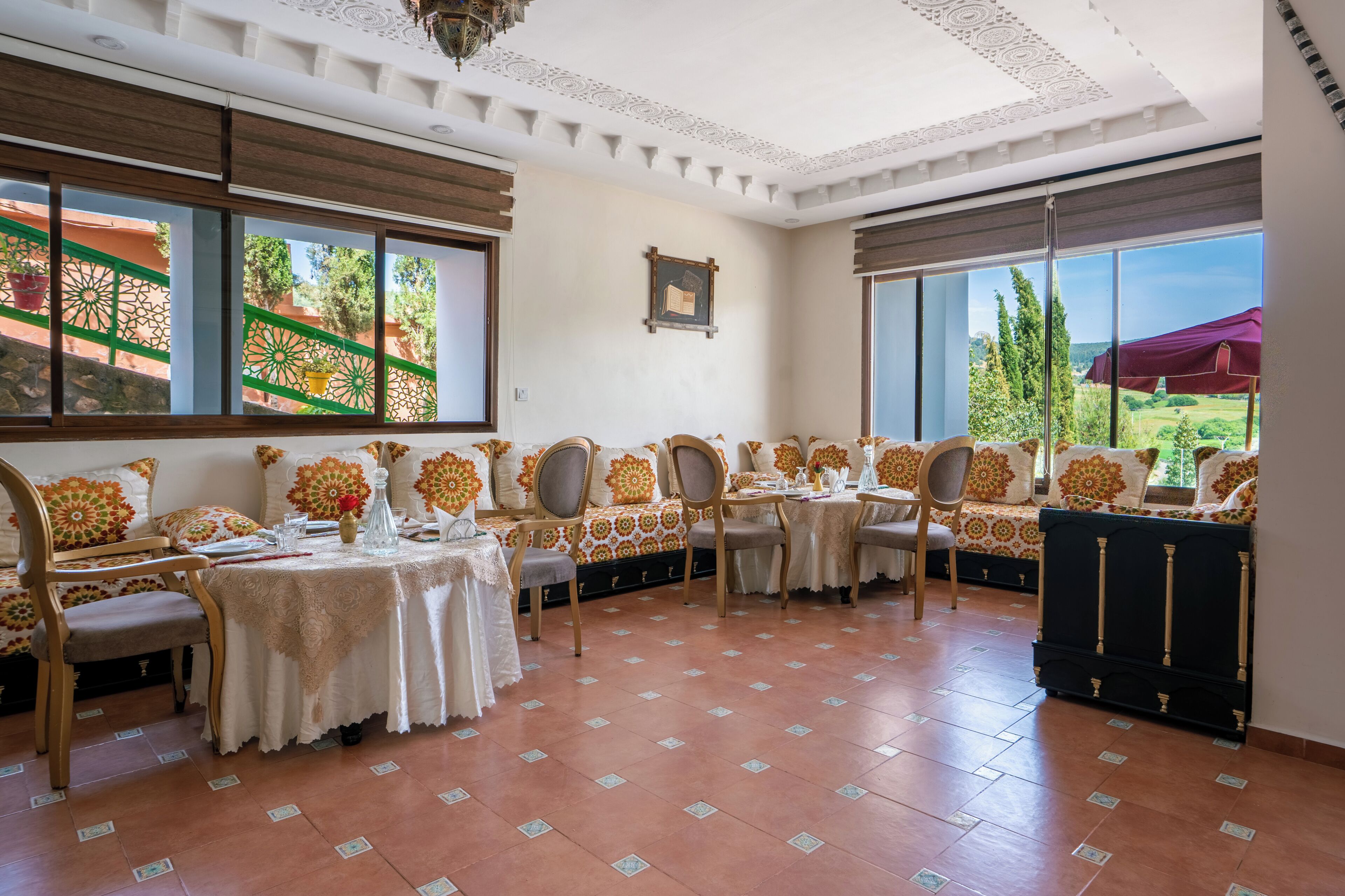 A dining area with a long table, chairs, and a view of the outdoors.