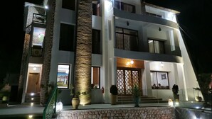 A modern two-story building with a stone facade, multiple balconies, and a well-lit entrance. - Dar Zayane (Mouha ou Hammou Zayani)