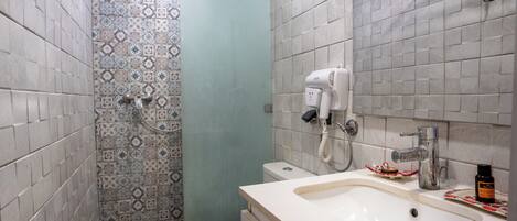 Un baño con inodoro, lavamanos y ducha.