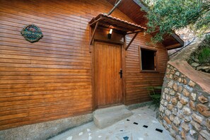 Un edificio de madera con puerta y ventana de madera.