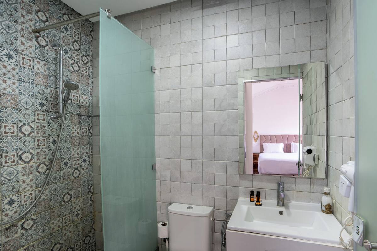 Deluxe driepersoonskamer | Badkamer | Een douche, een bidet, handdoeken, zeep