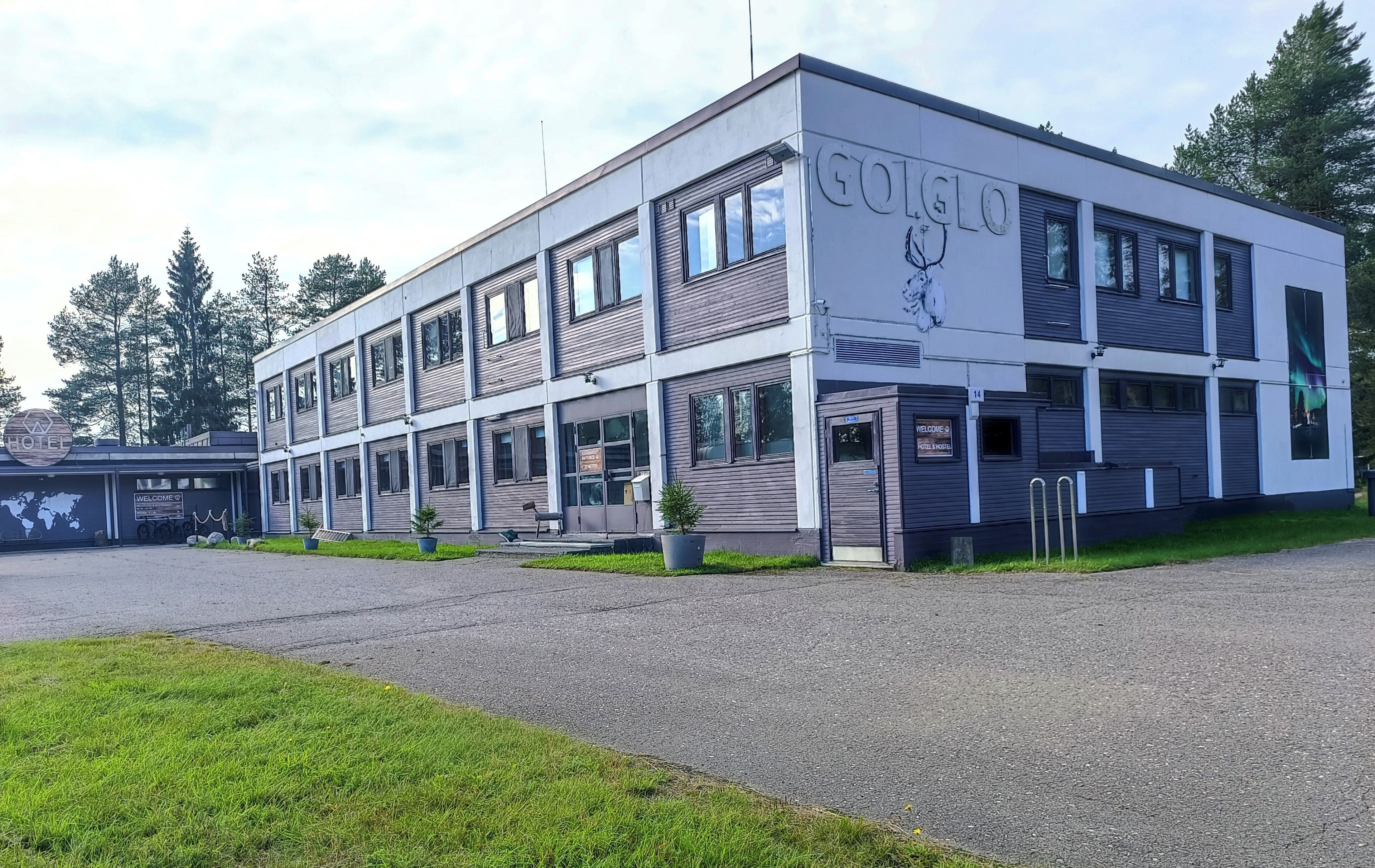 A modern hotel building with a sign reading "GOTGLO" and a welcome sign.