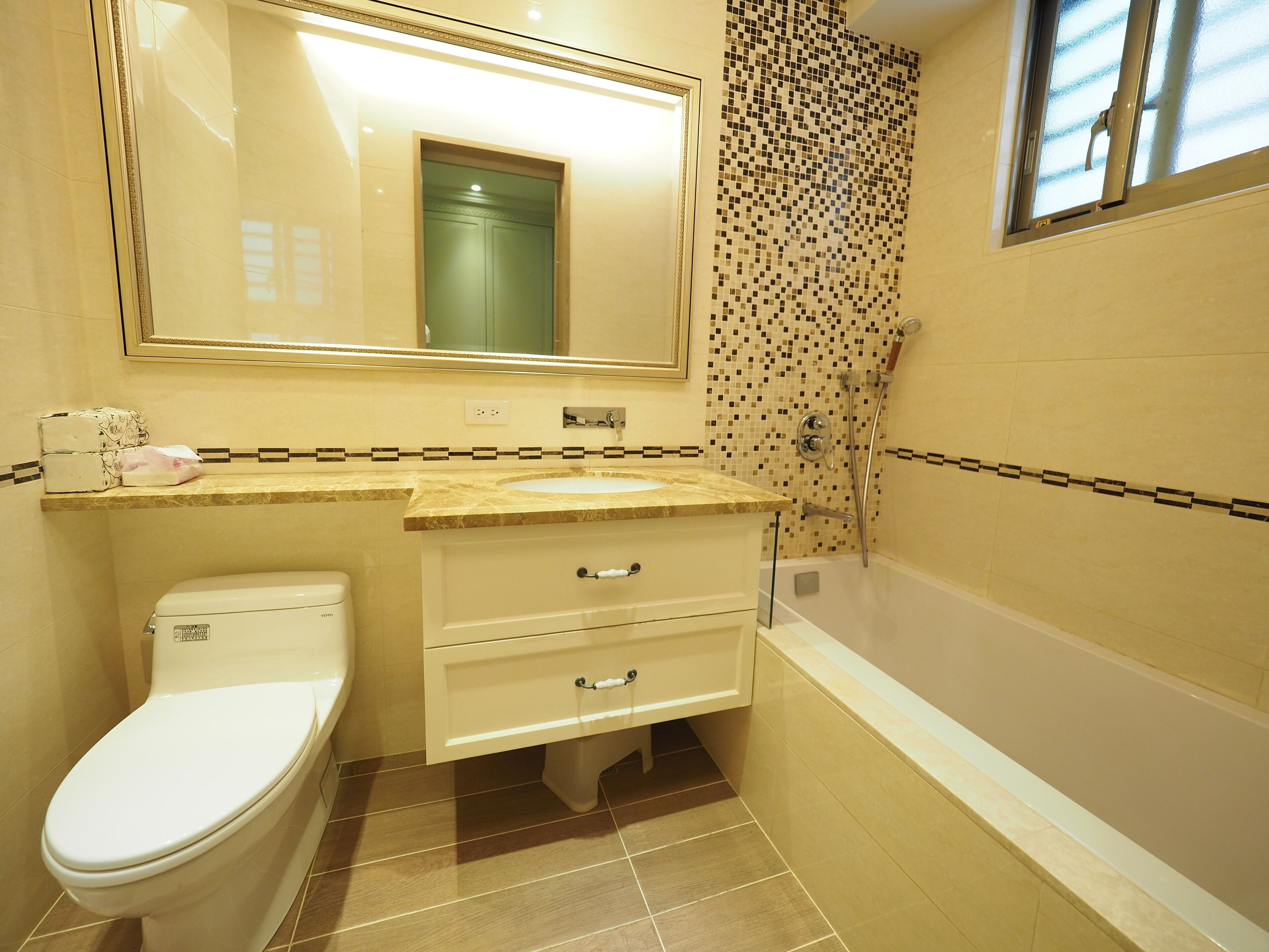 A bathroom with a toilet, sink, and bathtub.