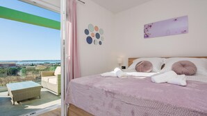A bedroom with a bed, pillows, a nightstand, and a view of the outdoors. - Beautiful home in Vrsi (Vrsi)