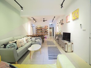 A modern living room with a sofa, coffee table, and TV. There are shelves with books and decorative items, and a dining area with chairs and a table. - luxury Linguang MRT station (Taipei)