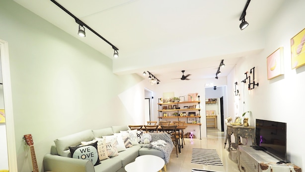 Ein modernes Wohnzimmer mit einer Couch, einem Couchtisch und einem Essbereich mit Stühlen und einem Tisch. Ein Fernseher, eine Gitarre und ein Bücherregal mit verschiedenen Gegenständen sind ebenfalls vorhanden.
