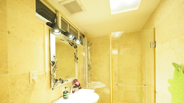 A bathroom with a glass shower door, a sink with a mirror, and a toilet. - SOGO & Park Homestay (Taipei)