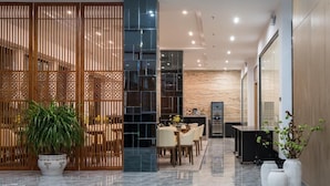 A modern lobby with a reception desk, seating area, and decorative plants. - Meeteem Boutique Hotel (Baise)