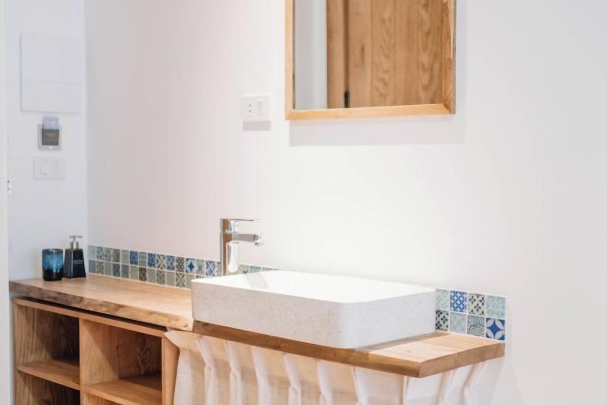 Une salle de bain avec un meuble-lavabo en bois, un lavabo blanc et un miroir.