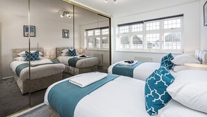 Een hotelkamer met twee bedden, een grote spiegel en een uitzicht buiten door grote ramen.