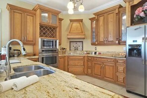 Enjoy cooking in this well-appointed kitchen with a double sink, refrigerator, oven, and microwave.