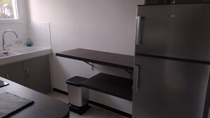 A modern kitchen with a stainless steel refrigerator, a sink, and a countertop. - WATERFRONT APARTMENT (Jard-sur-Mer)