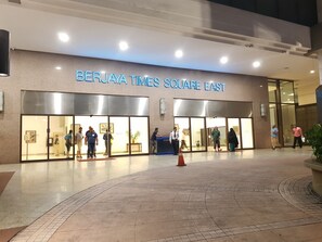 El exterior del hotel Berjaya Times Square East, con fachada moderna, amplios ventanales y un área de acceso visible.