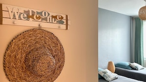 Une pièce décorée d’une tapisserie murale tissée et d’une pancarte indiquant « Bienvenue ».