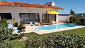 A modern house with a swimming pool, outdoor seating, and a well-maintained garden. - 3 Bedroom villa with swimming pool in quiet village with countryside views (Alcobaca)