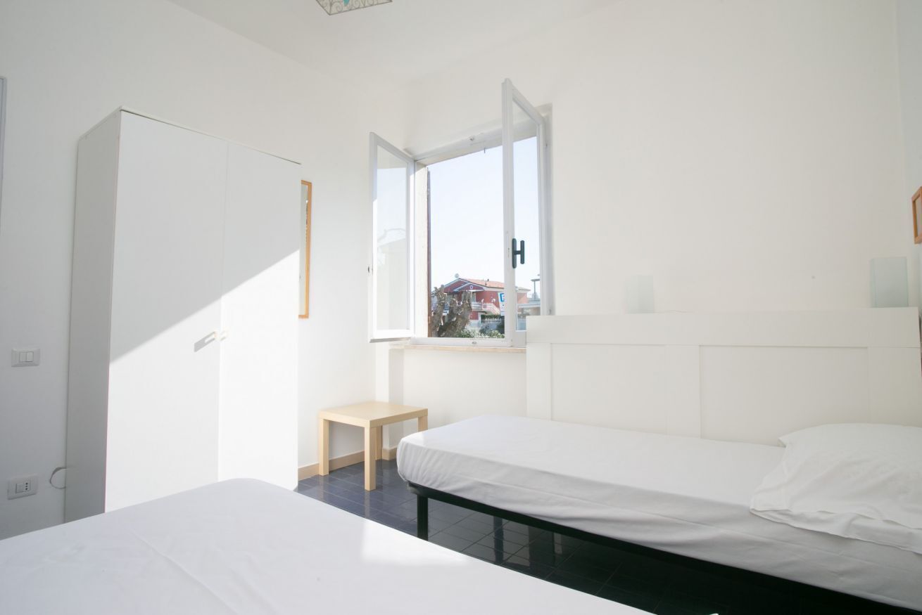 Una camera da letto con un letto, un tavolino, un armadio e una finestra vista.