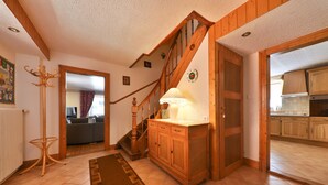 A wooden staircase with a lamp, a coat rack, and a patterned rug in a home interior. - Maison Balboa gîtes for 2 to 12 people (Sondernach)