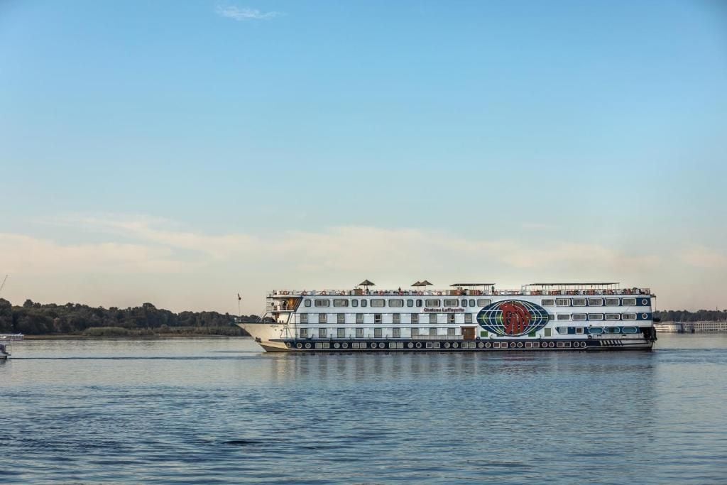 Un bateau fluvial à plusieurs ponts, orné d’un logo sur le côté.