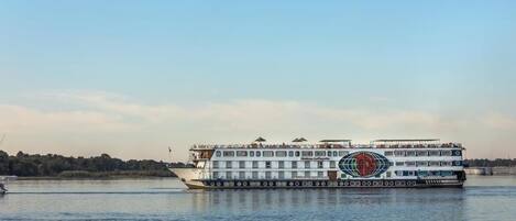 A riverboat with multiple decks and a logo on the side.