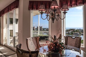 Relax in this stylish room with a large glass table, wicker chairs, and a chandelier. Enjoy the view of the city and water from the large windows.