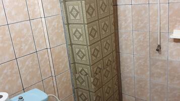 Un baño con inodoro, lavamanos y ducha.