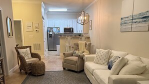 A living room with a ceiling fan, a dining area with a kitchen in the background, and a patterned rug. - *30A Seagrove Highlands Ground Floor Unit- 2 bikes included (Santa Rosa Beach)