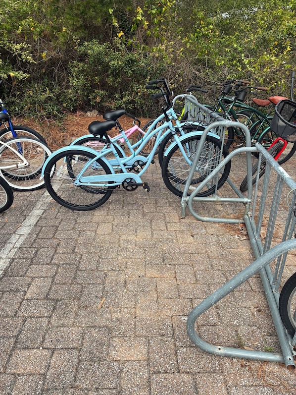 A bicycle parking area with multiple bikes and a metal bike rack. - *30A Seagrove Highlands Ground Floor Unit- 2 bikes included (Santa Rosa Beach)