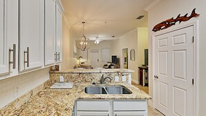 A kitchen with white cabinets, granite countertops, a double sink, and a chandelier. - *30A Seagrove Highlands Ground Floor Unit- 2 bikes included (Santa Rosa Beach)