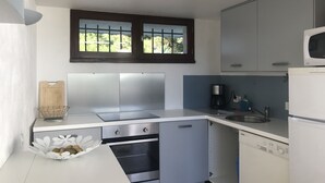 Cocina compacta con microondas, horno y lavamanos.
