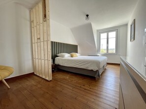Un dormitorio con una cama, un armario de madera y una ventana.