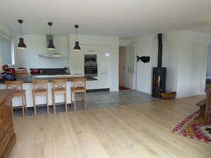 A modern kitchen with white cabinets, a central island, and pendant lighting.